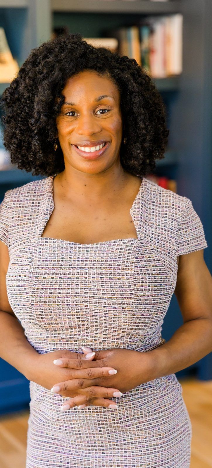 Cassandra Davis smiling in front of a bookshelf